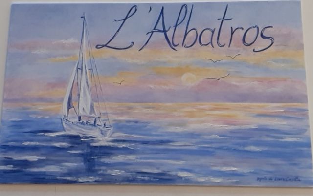 Barca a vela su un oceano sereno, con un cielo al tramonto e la scritta