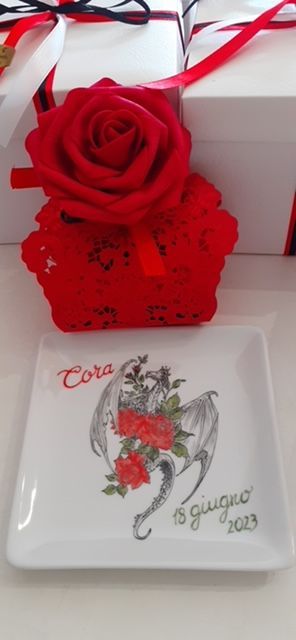 Un piatto quadrato bianco con dipinto un drago e delle rose