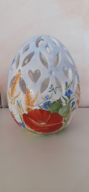 Uovo in ceramica bianca con ritagli di fiori e papavero rosso dipinto.