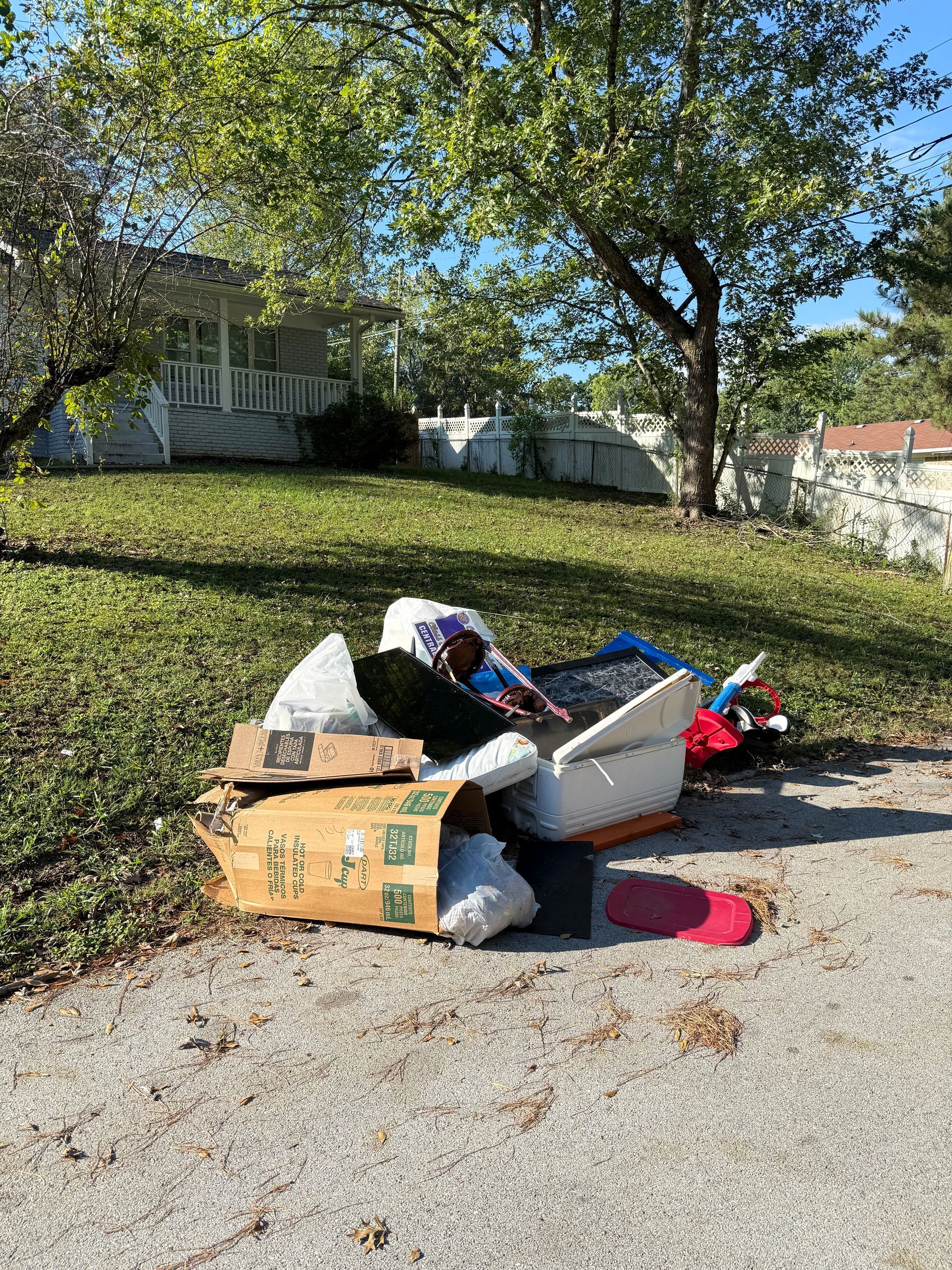 A pile of trash is sitting on the side of the road.