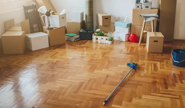 A room filled with boxes and a mop on the floor.