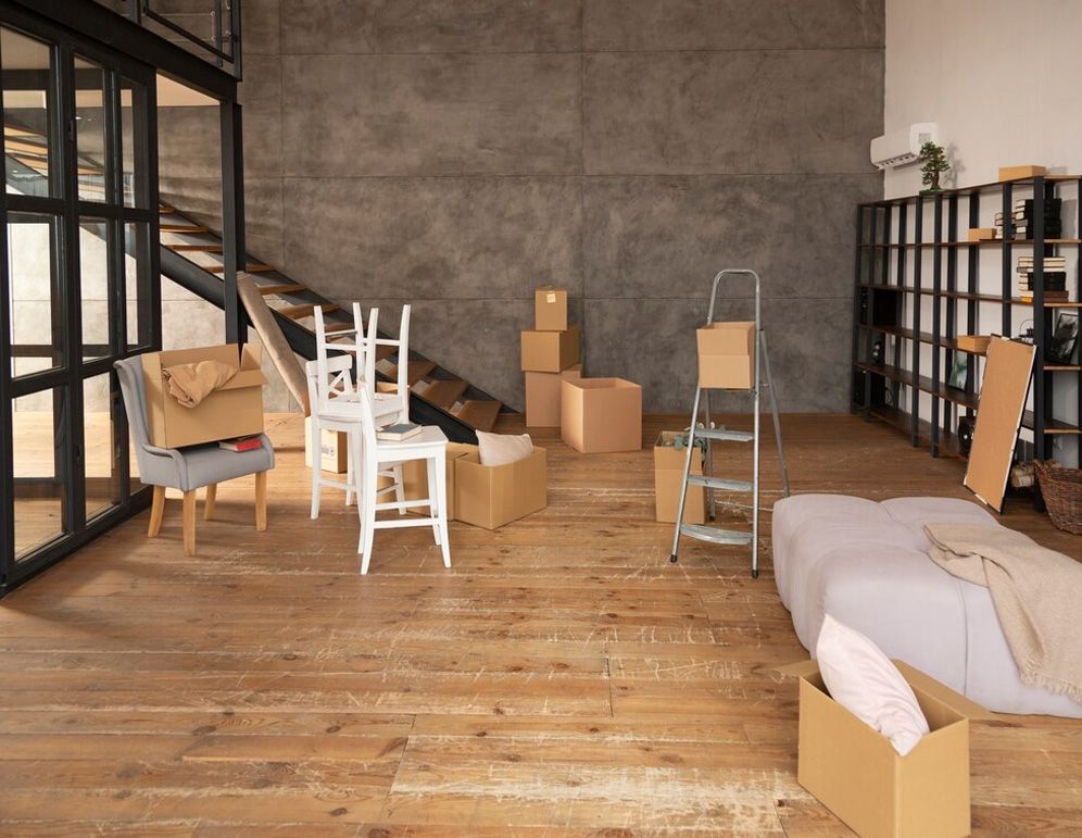 A living room filled with lots of cardboard boxes and furniture.
