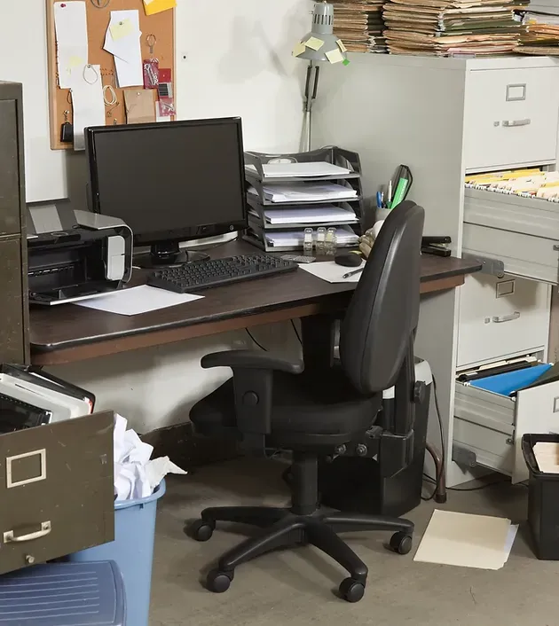 A desk with a computer on it and a chair