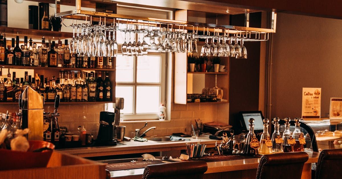 A bar filled with lots of bottles of alcohol and wine glasses.
