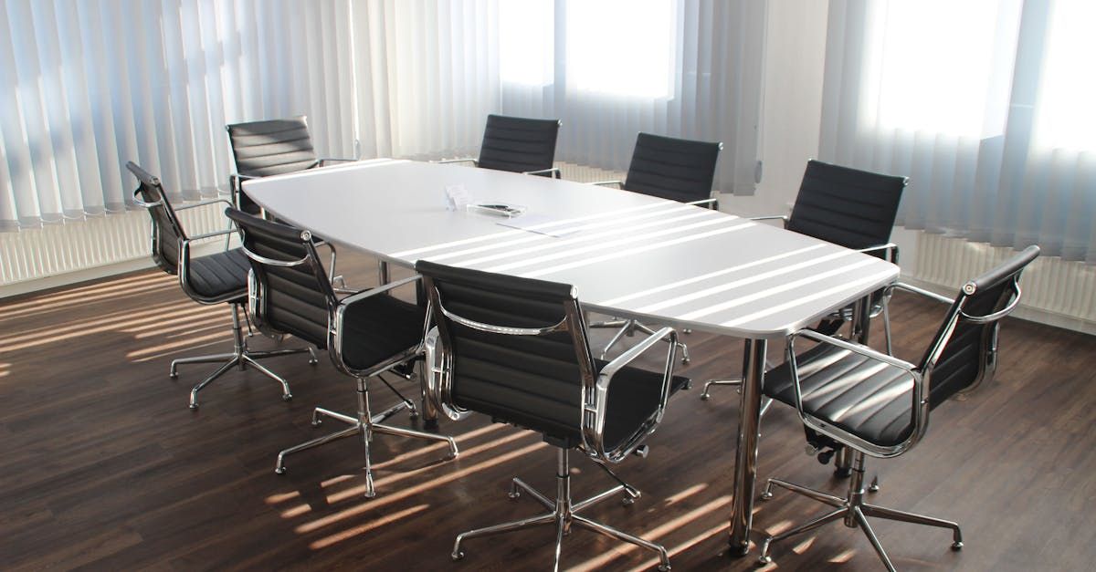 A conference room with a long table and black chairs