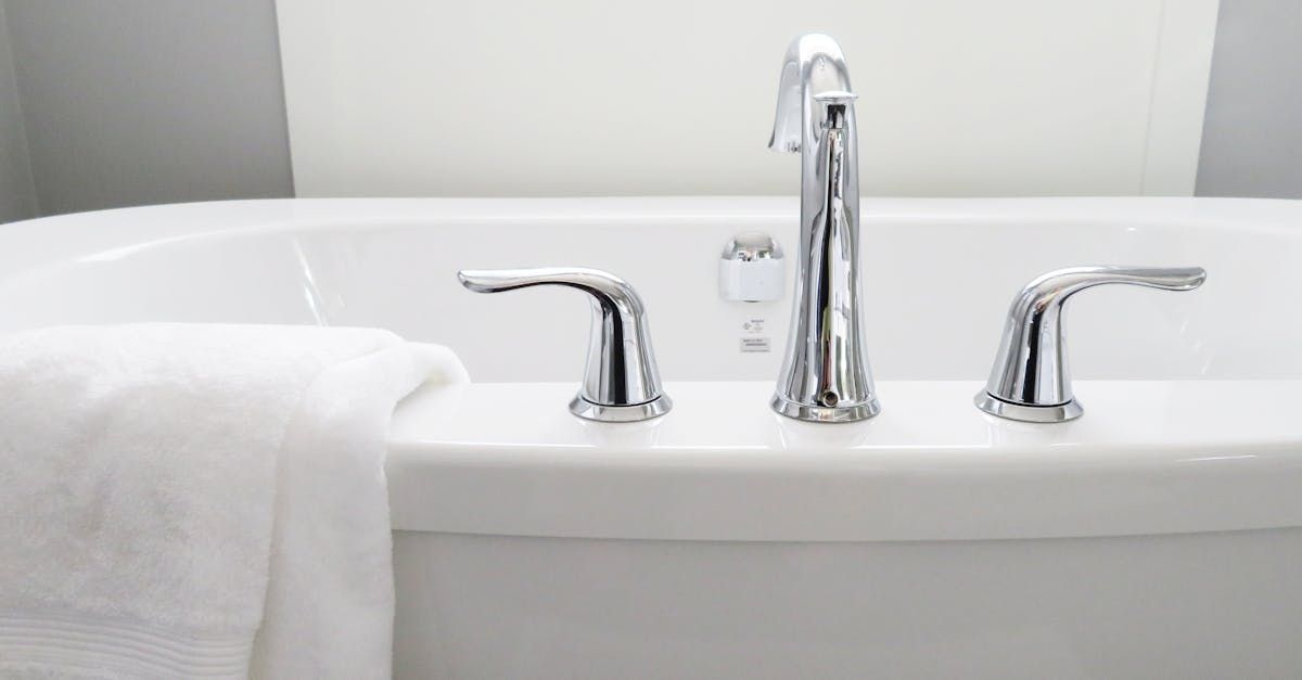 A bathtub with a towel and a faucet in a bathroom.
