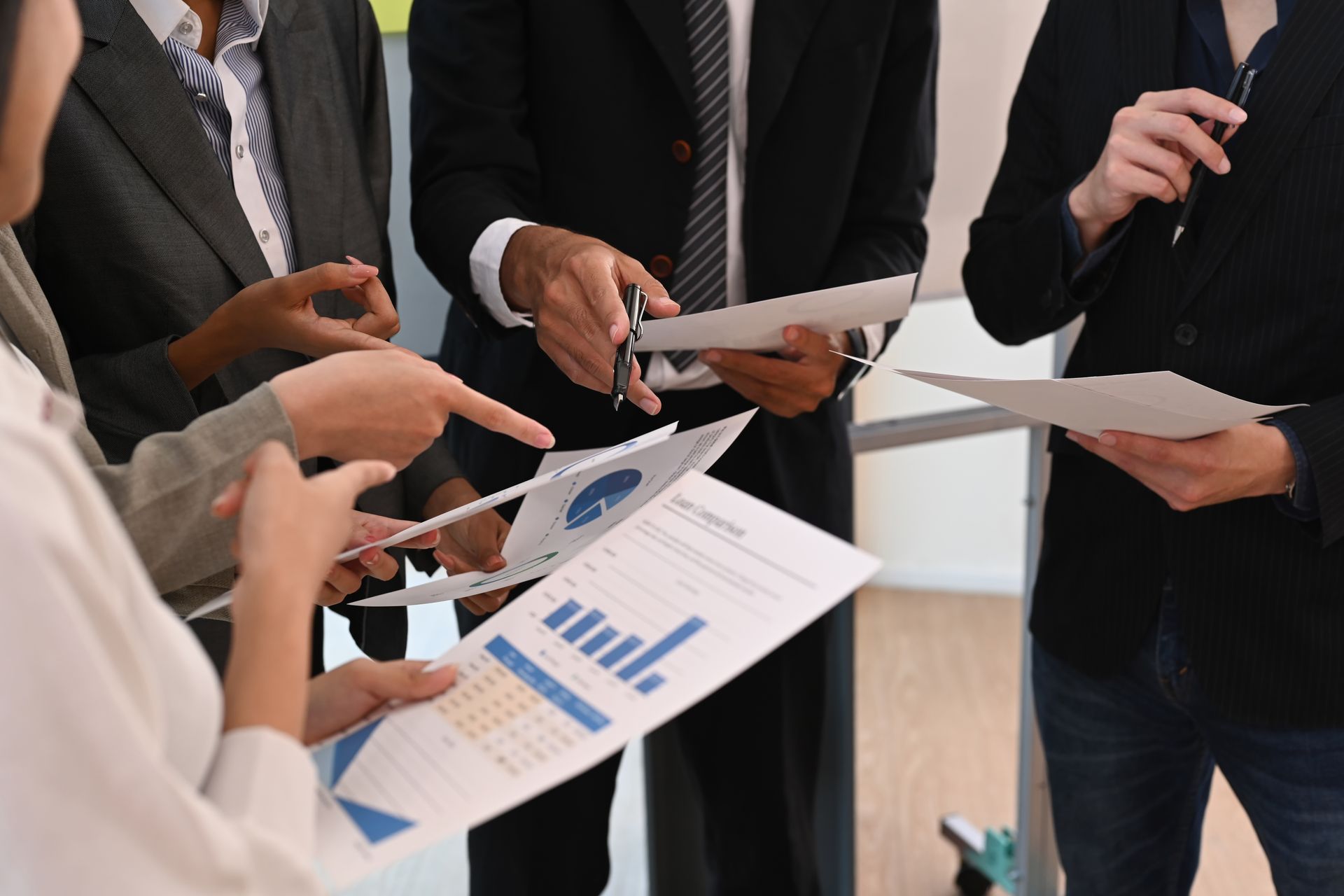 A group of people are standing around a table looking at papers.