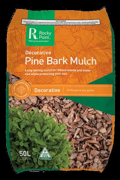A Bag of Pine Bark Mulch with A Plant in The Background — Edmonds Landscaping Supplies in Bohle Plains, QLD