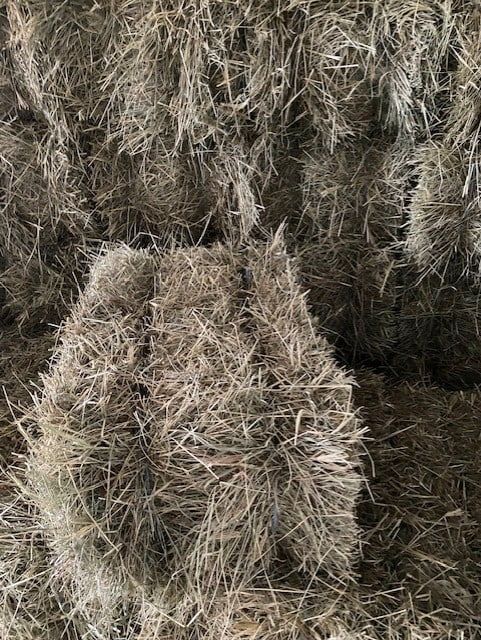 A Pile of Hay Is Sitting on Top of Each Other in A Barn — Edmonds Landscaping Supplies in Bohle Plains, QLD