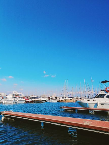 Marina with docked boats on blue water under a clear bright sky