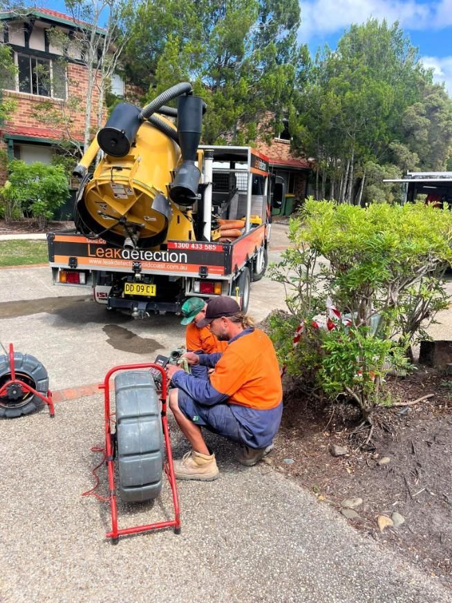 Two Men Are Working on a Drain in Front of a Truck — Gold Coast Leak Detection in Mudgeeraba, QLD