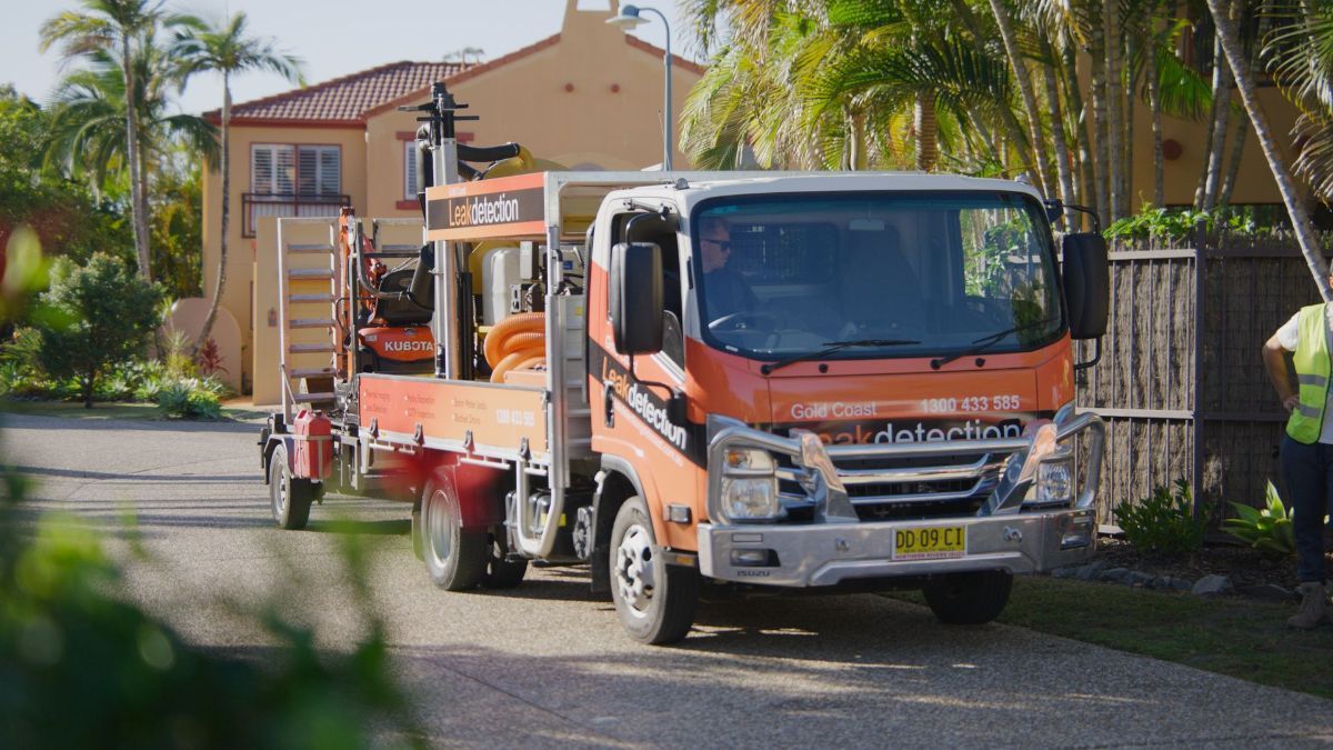 A Man Wearing a Hard Hat is Working on a Pipe in the Dirt — Gold Coast Leak Detection in Burleigh Heads, QLD