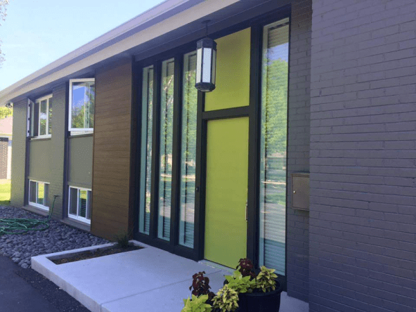 A house with a yellow door and a lot of windows