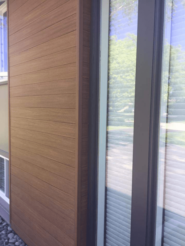 A close up of a wooden wall next to a window.