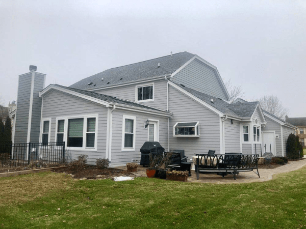 A large house with a lot of windows and a patio in front of it.