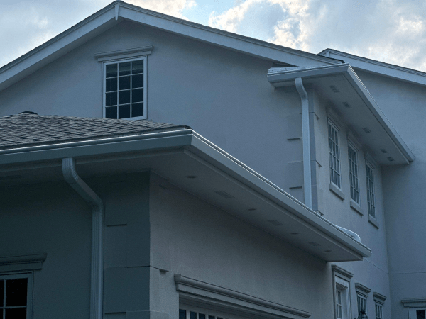 A large white house with a roof and gutters