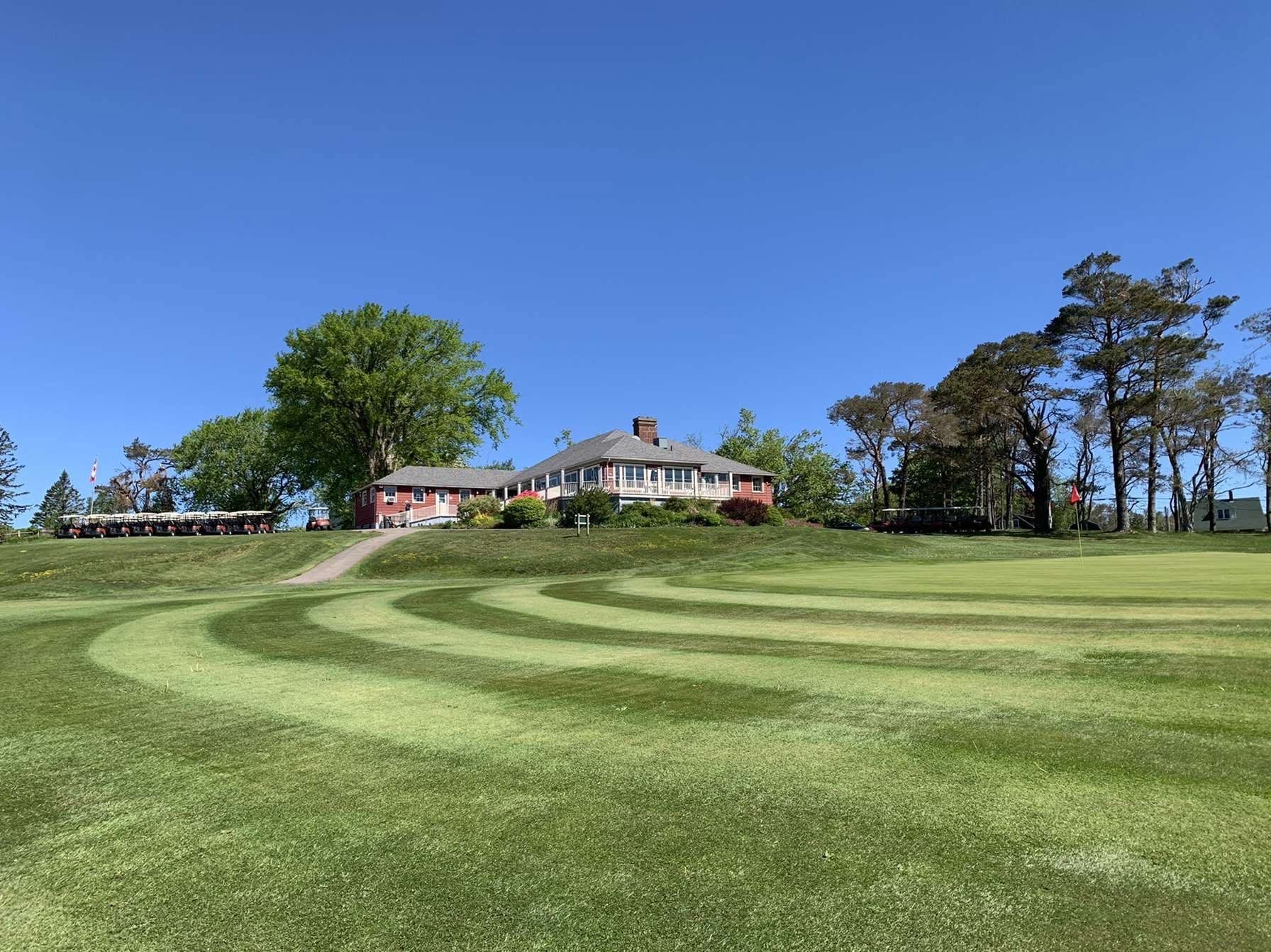 A golf course with a house in the background