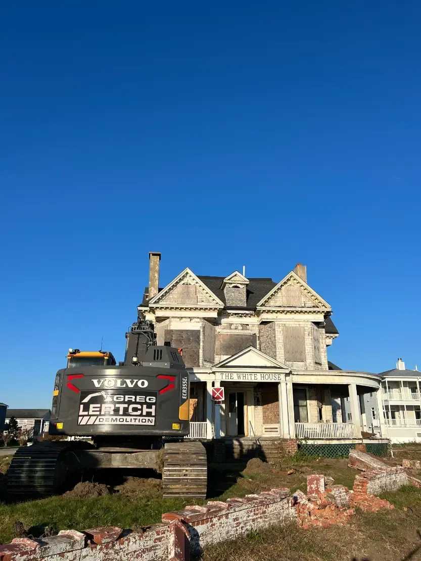 An old house is being demolished by a volvo excavator