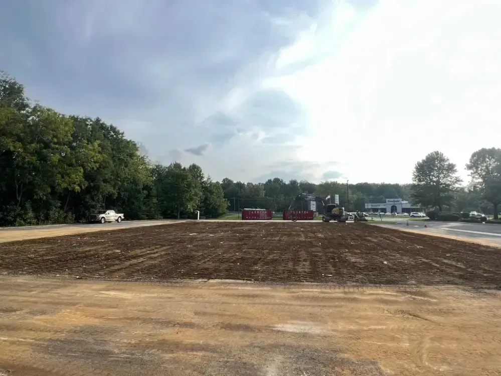 A large dirt field with a lot of dirt and trees in the background.