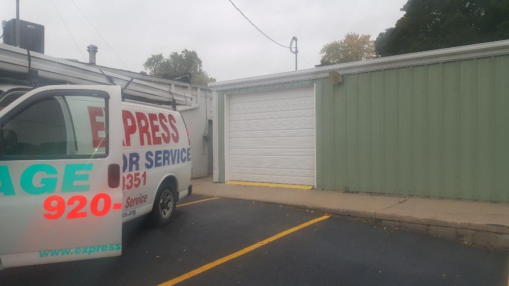 Parking lot beside a white and green building, with a service van marked “PRESS AIR SERVICE” in the foreground