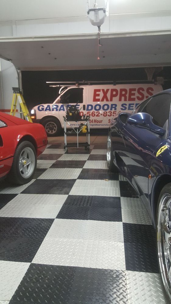 Garage with checkerboard floor and parked cars in front of an Express Door Service sign