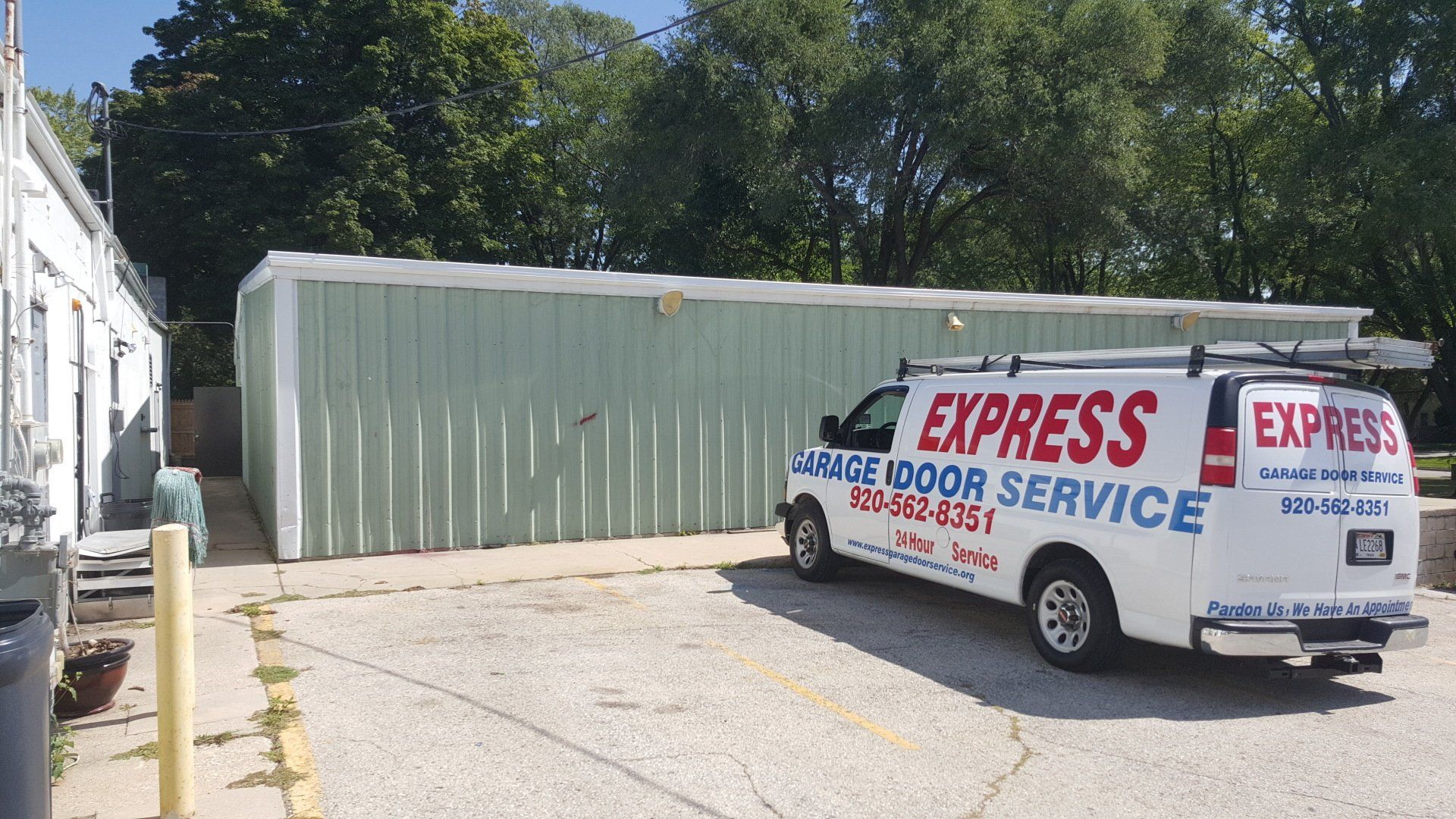 White Express Moving Service van parked beside a large beige storage container in a sunny lot