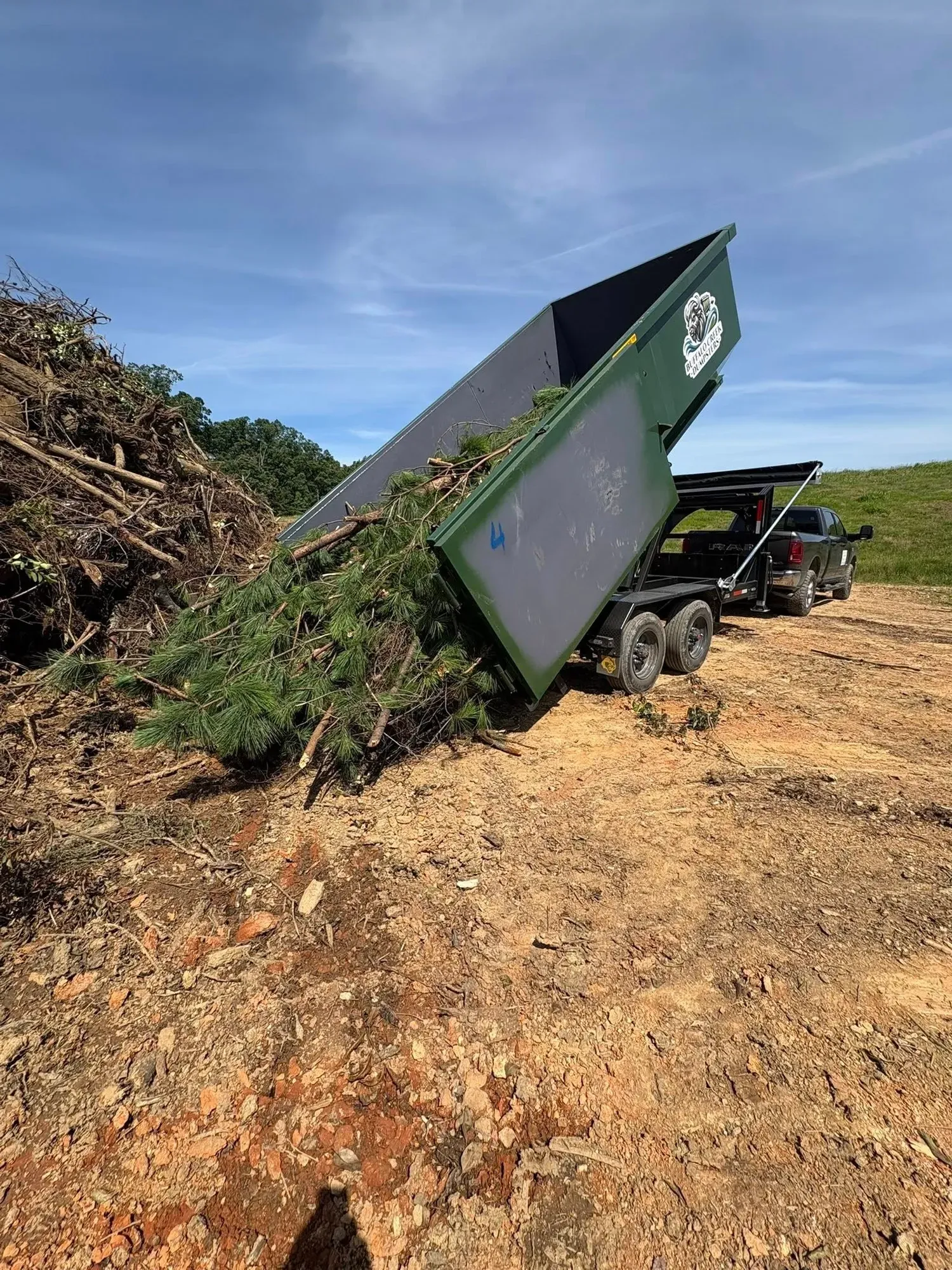 A photo showing Buffalo Creek Dumpsters dumping organic yard waste. 