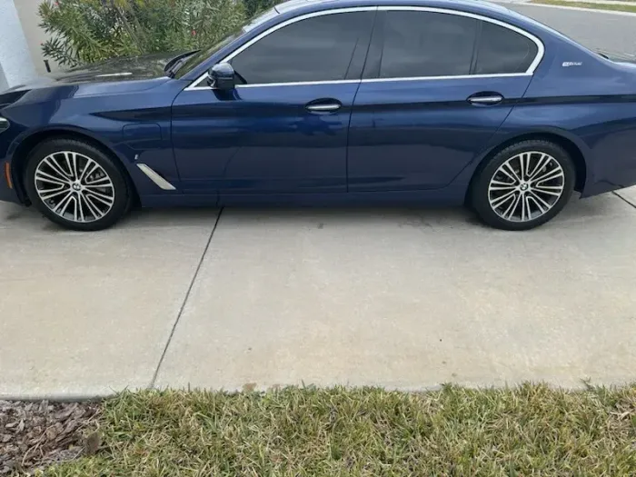 Blue sedan parked in a driveway on a cloudy day