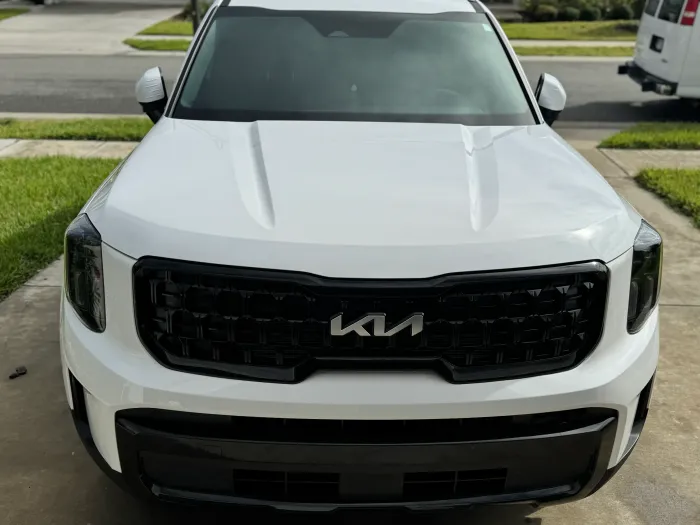 Front view of a white Kia SUV parked in a driveway