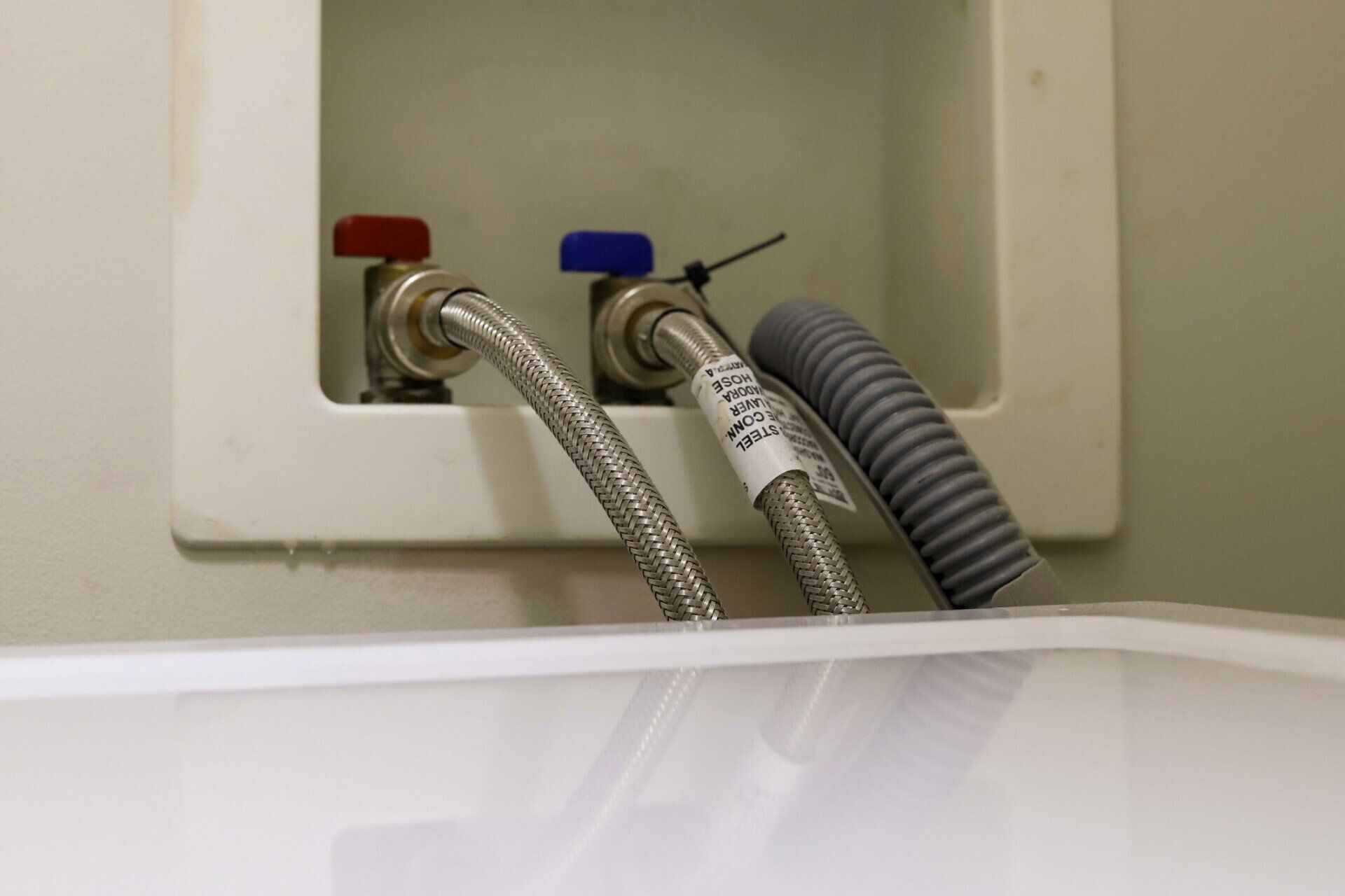 Washing Machine Drain Hose On A Wall — Houston, TX — Richter’s Services Inc.