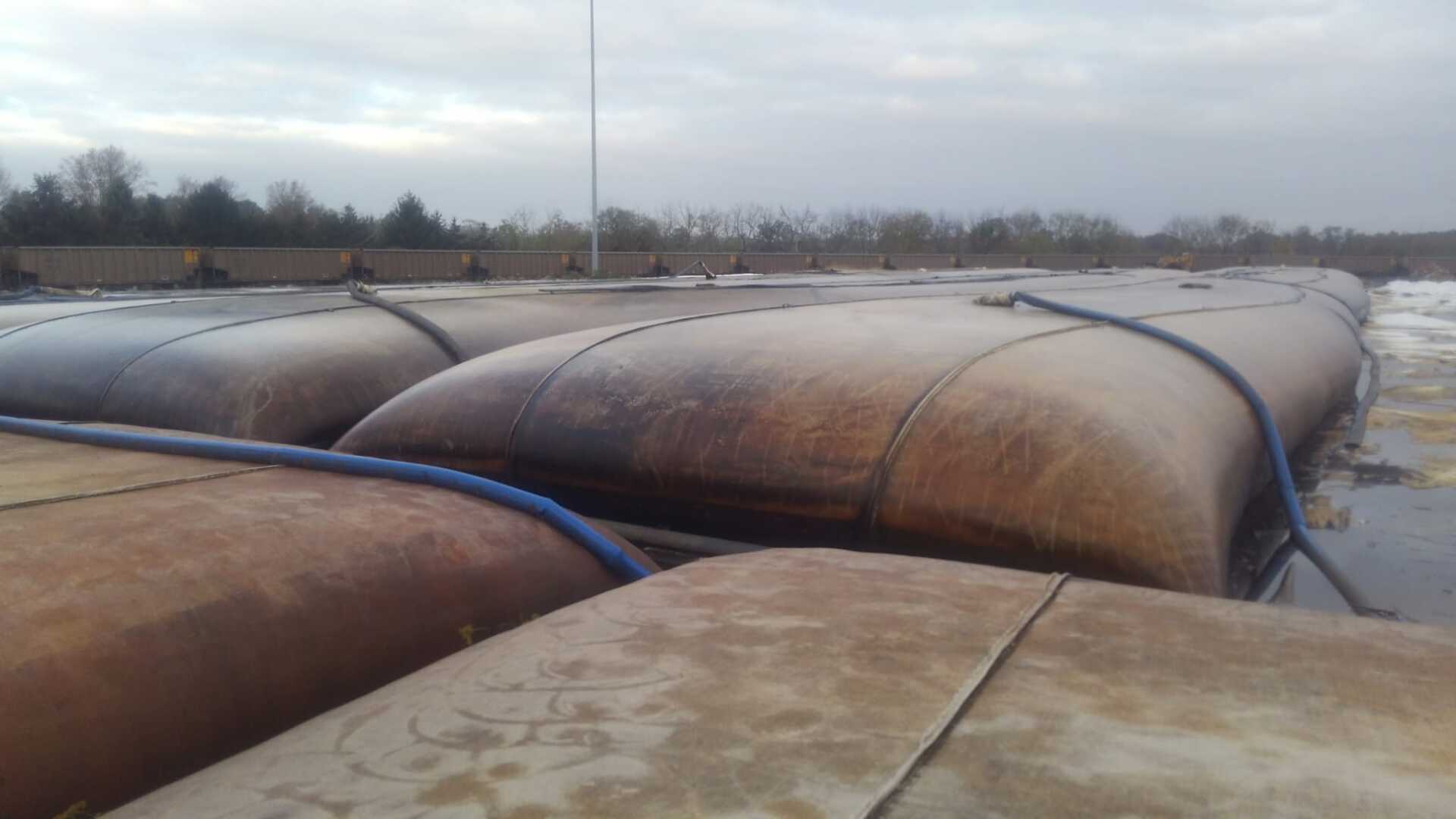 A bunch of barrels are sitting on top of a concrete surface.