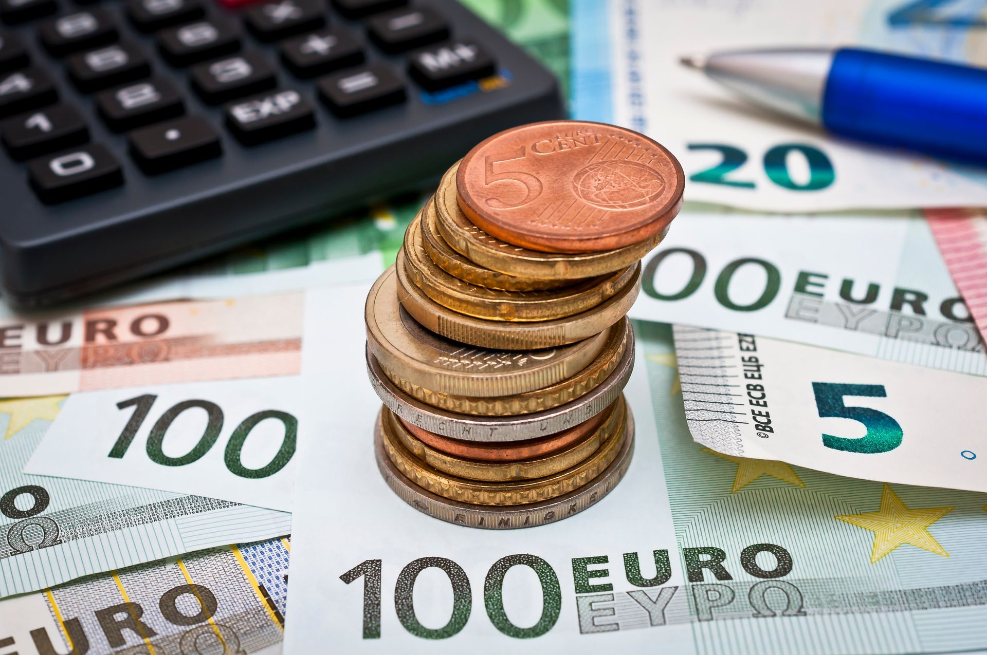 Auf verschiedenen Euro-Banknoten liegt ein Stapel Euro-Münzen;