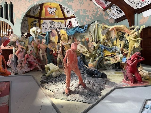Colorful sculptural installation with abstract human figures in a gallery space