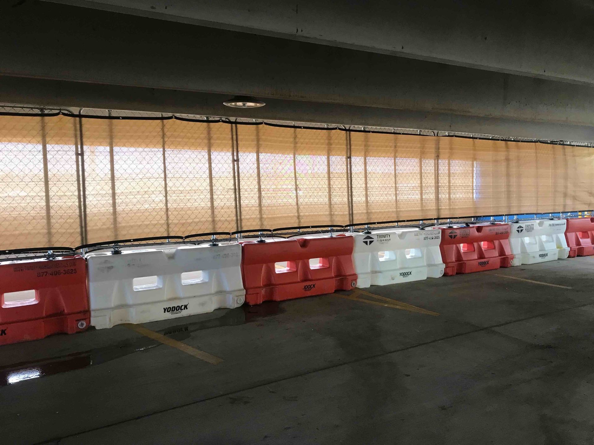 A row of water filled barriers in a parking garage.