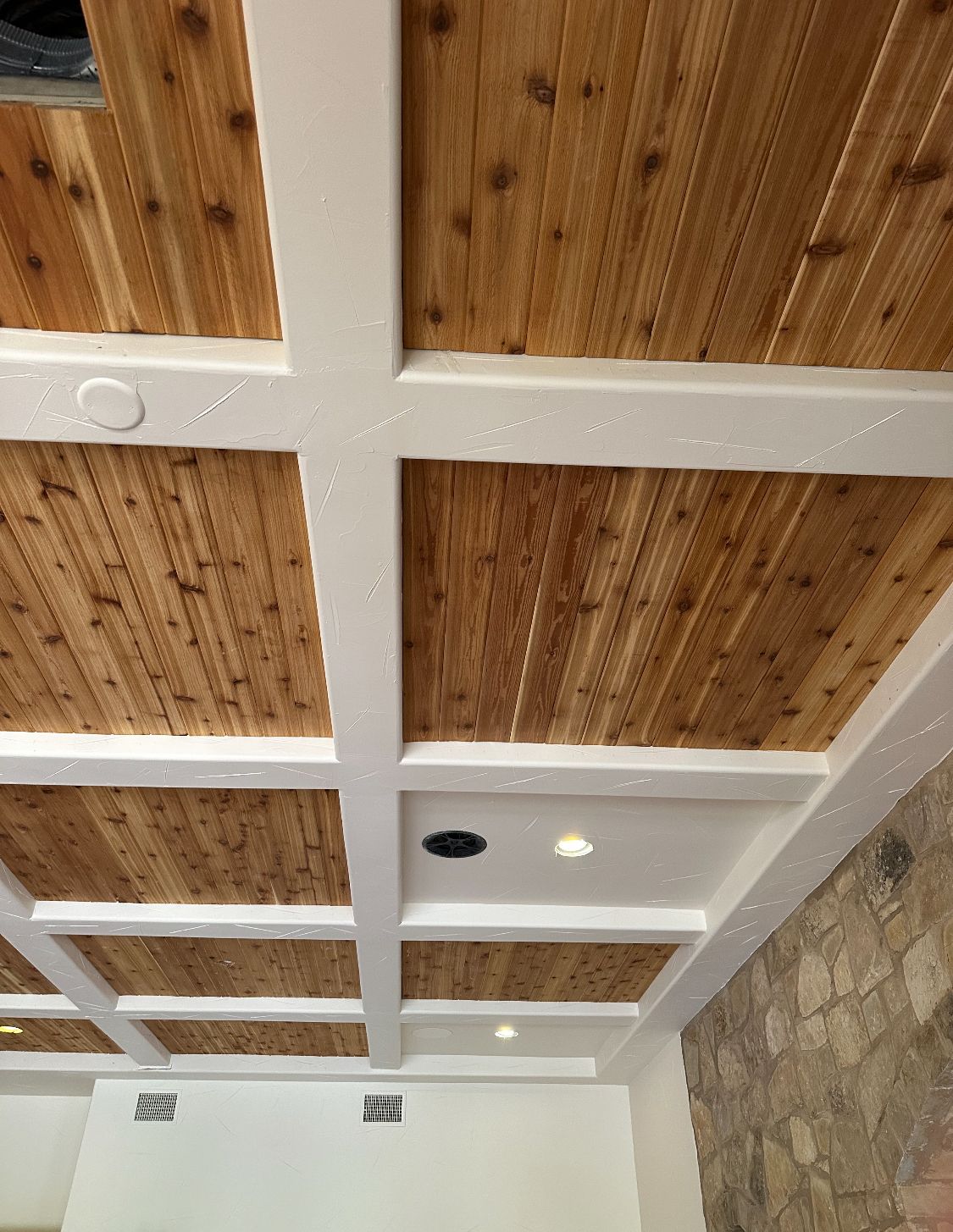 A wooden ceiling with white beams in a room.
