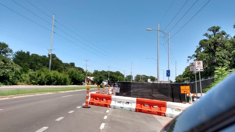 A construction zone on the side of a road with traffic control