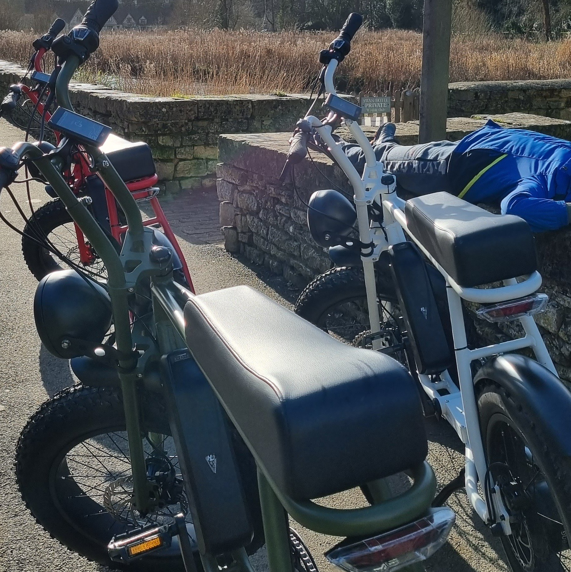 Two bikes are parked next to each other on the side of the road
