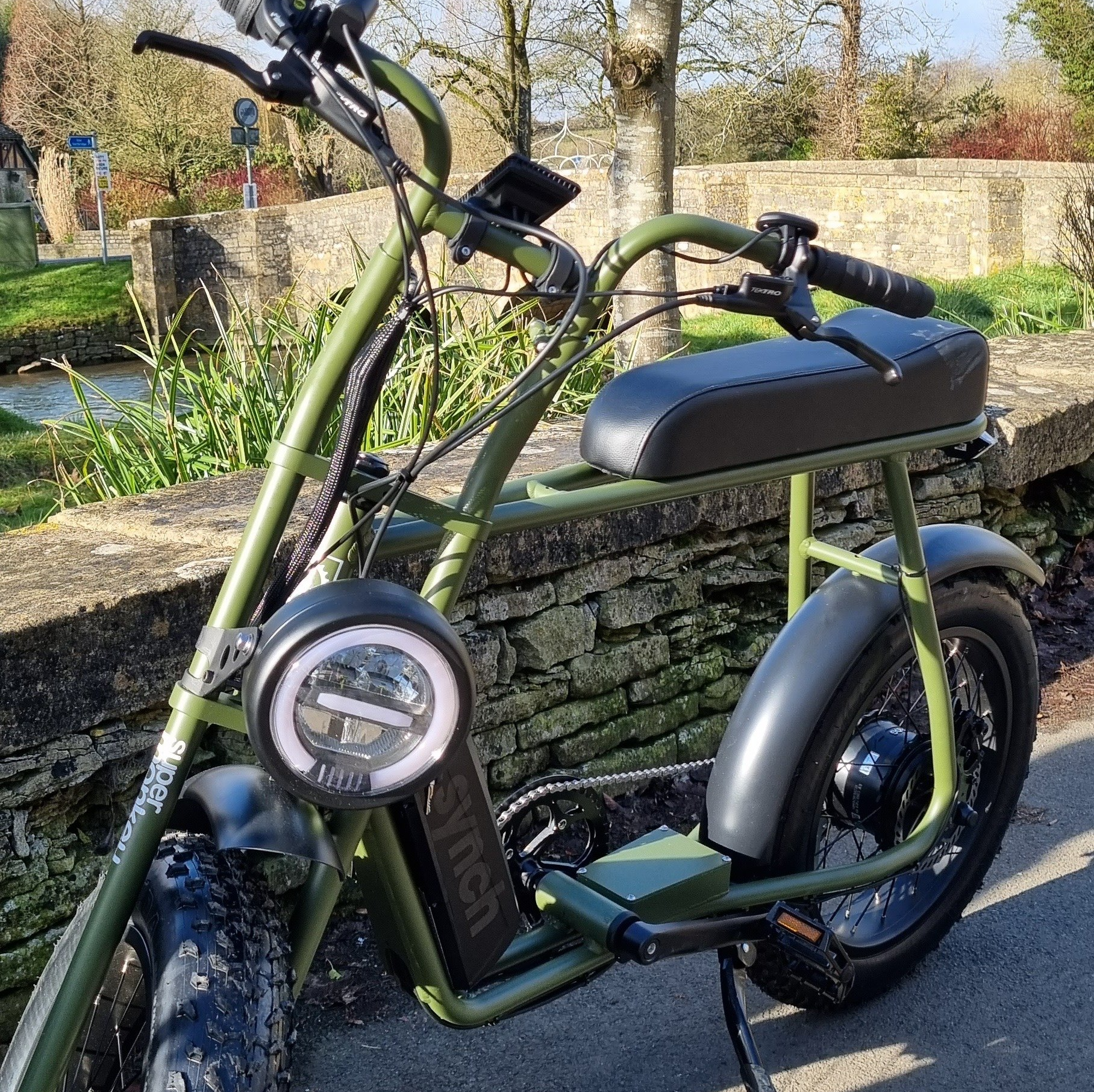A green and black motorcycle is parked on the side of the road.