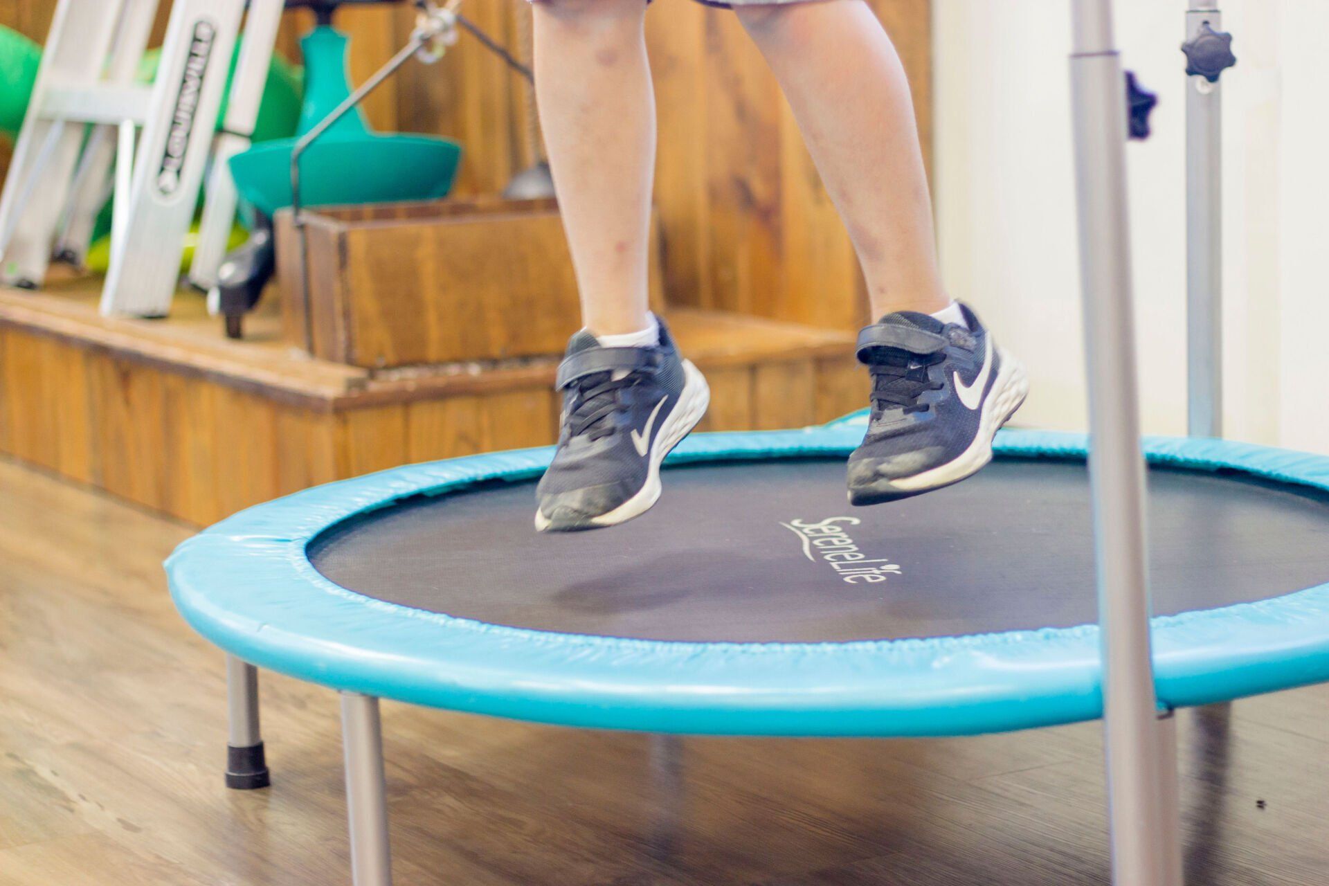 Person jumping on a blue trampoline in a gym interior