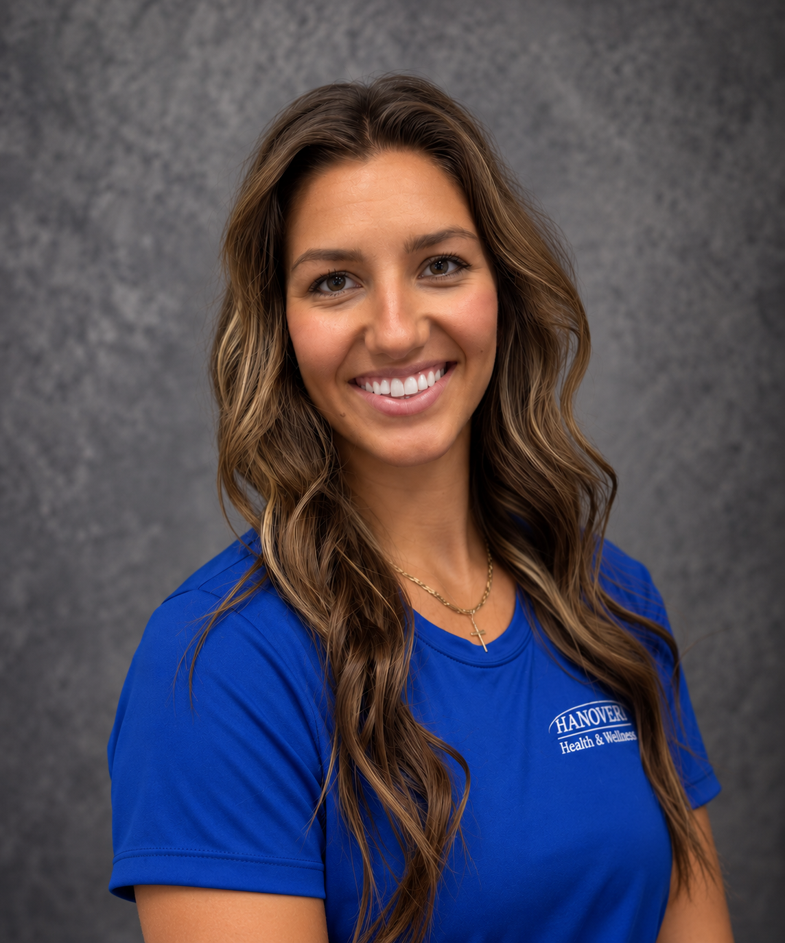 Smiling woman in a blue shirt against a gray studio backdrop