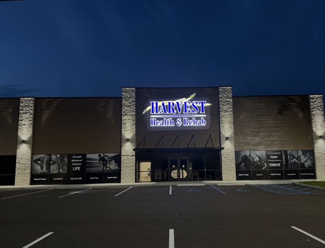 Night view of a Hibbett Sports storefront with lit sign and empty parking lot