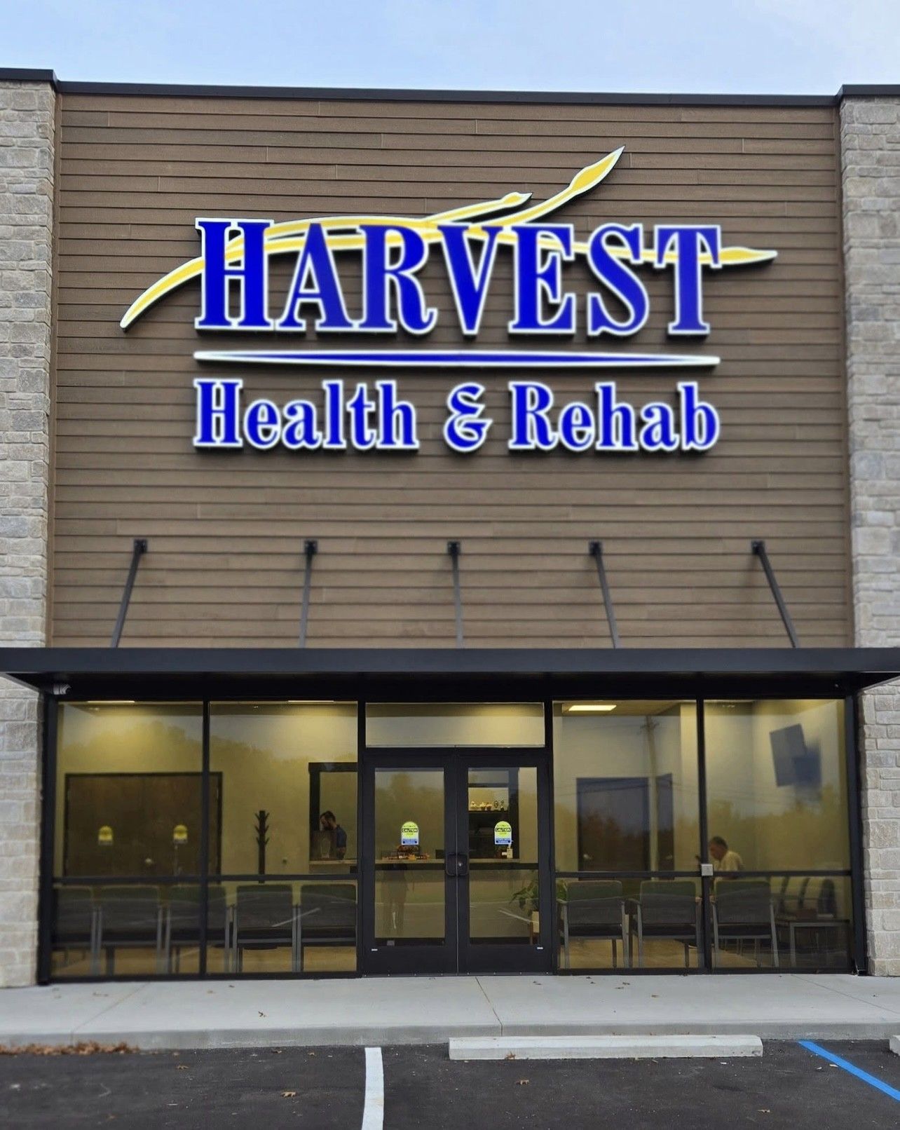 HARVEST Health & Rehab storefront with tan facade, blue sign, and covered entrance