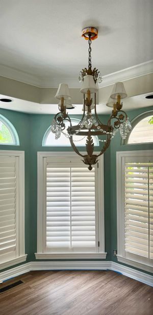Empty room with wood-look floor, window with blinds, and ceiling light fixture.