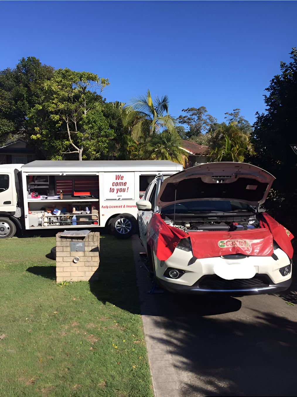 A Man is Working on a Red Car With the Hood Up — Coffs Coast Mobile Mechanical in Toormina, NSW