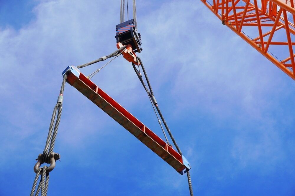 A Crane Is Lifting A Large Piece Of Wood In The Air — J & D Rigging Pty Ltd In Bohle, QLD