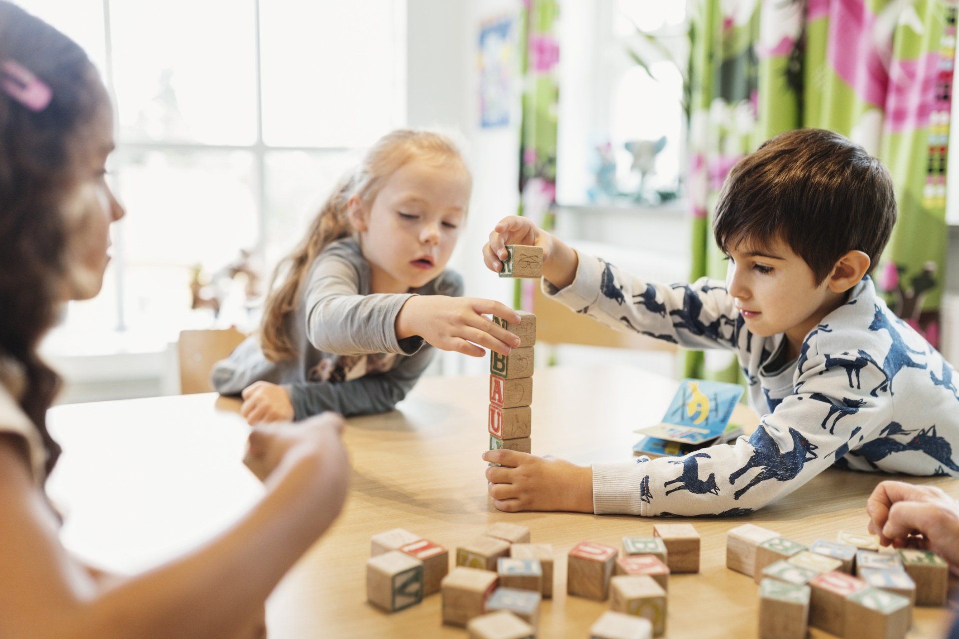 Children stacking alphabet blocks on table — Verona, WI — Once Upon a Time Childcare Center Children stacking alphabet blocks on table — Verona, WI — Once Upon a Time Childcare Center