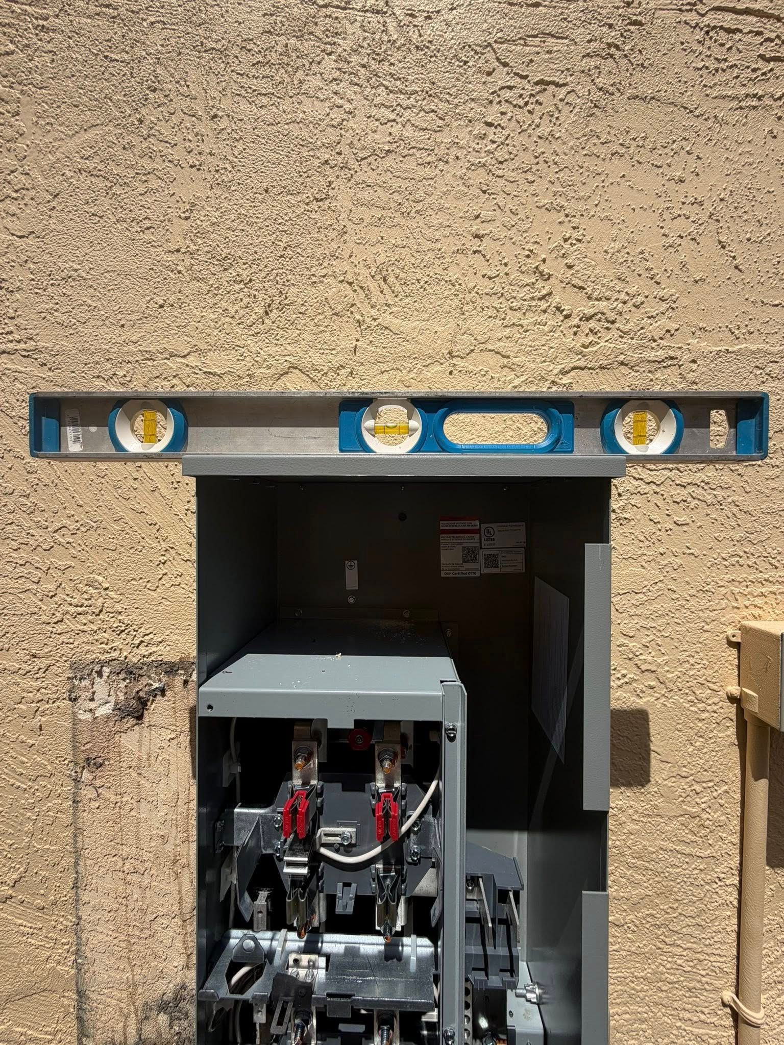 Industrial machine inside a beige wall opening with blue level tools mounted above the doorway