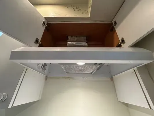 Open refrigerator with empty shelves and a light on inside