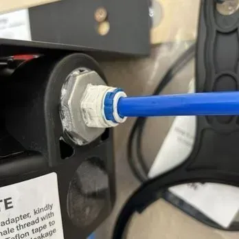 Blue cable plugged into a white connector on a black machine panel
