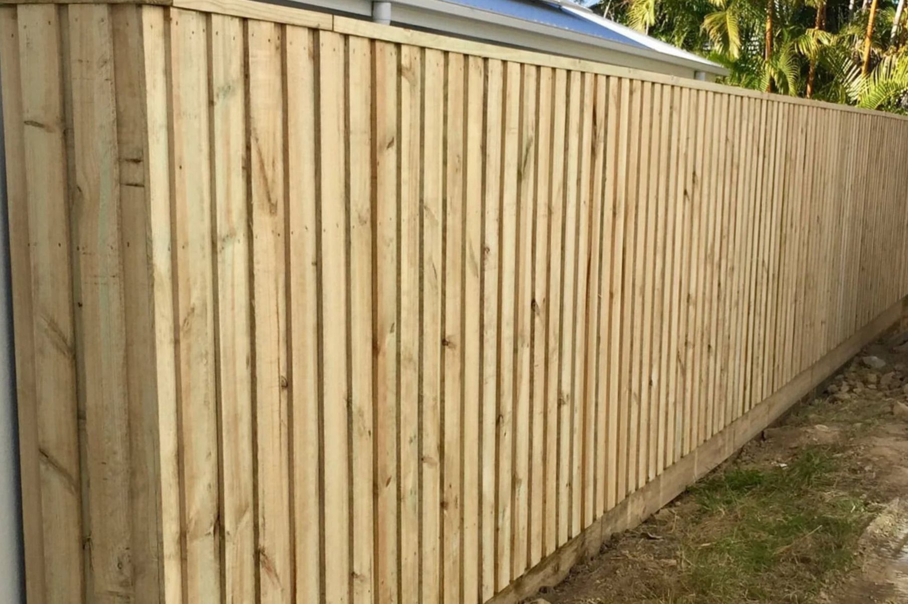 Wooden Privacy Fence Along A Grassy Yard Under A Blue Sky — Frontline Fences in Tweed Heads South, NSW